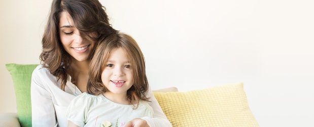 Smiling mother with little girl who lost a tooth